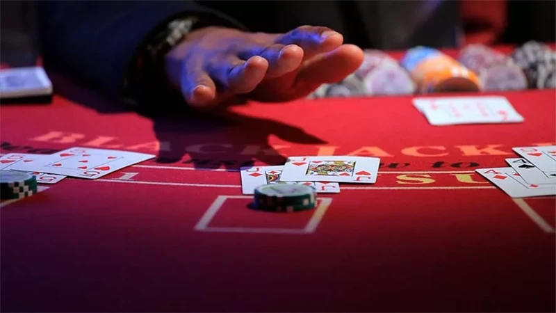 Blackjack strategy guide showing when to hit cards with dealer bust zones highlighted and probability indicators on casino table